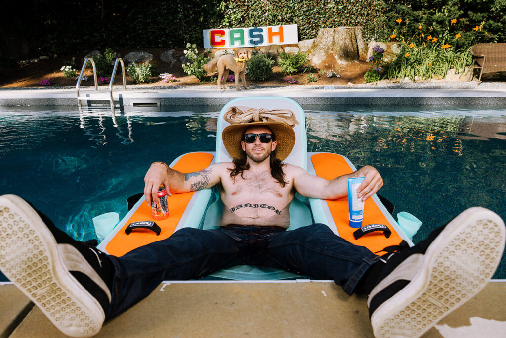 Comedian Jimmy Cash floats in a pool wearing his jeans and sneakers